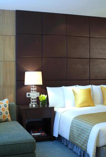 a bedroom with a large bed and a chair at Courtyard by Marriott Kunshan in Kunshan