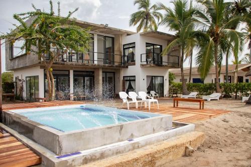 a villa with a swimming pool in front of a house at Taipan Casa de Playa in El Puertón