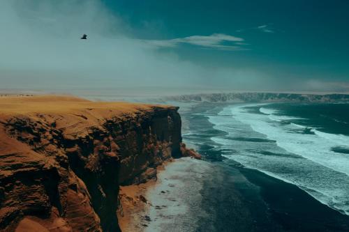 an aerial view of the ocean and a cliff at Hotel Riviera Inka Paracas in Paracas