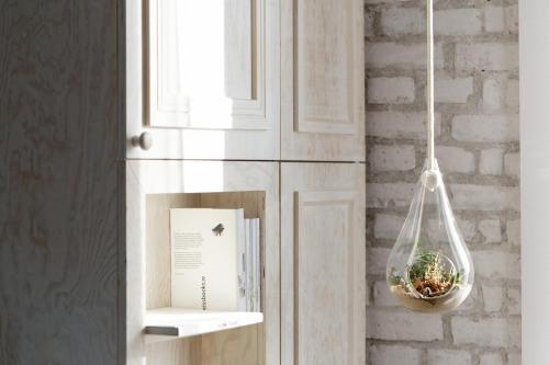 a glass jar hanging from a wall with a plant at Libertine Lindenberg in Frankfurt/Main
