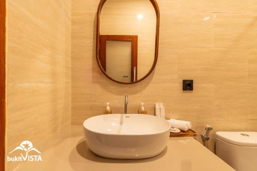 a bathroom with a white sink and a mirror at The Pandawa Bali by Bukit Vista in Nusa Dua