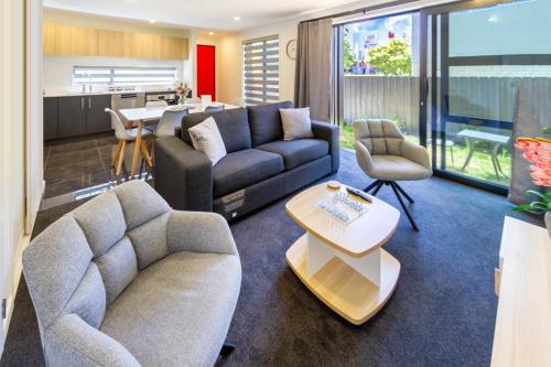 a living room with a couch and a table at Relaxing stay across from Westfield mall Sleeps 6 in Christchurch