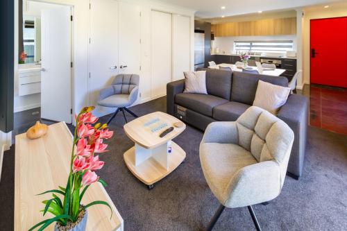 a living room with a couch and chairs and a table at Relaxing stay across from Westfield mall Sleeps 6 in Christchurch