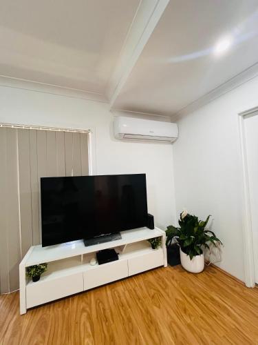 a living room with a large flat screen tv at Lovely Modern Family home for your family and friends in Narwee