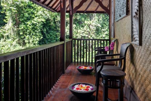 a screened porch with two chairs and two bowls of candy at Bidadari Private Villas & Retreat in Ubud
