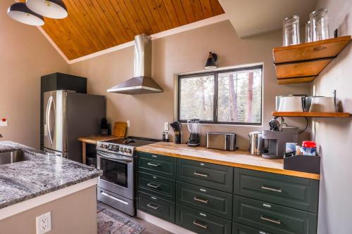 a kitchen with green cabinets and a counter top at Aspen Chalet Hot Tub, Fire Pit, Games,1-Acre in Durango