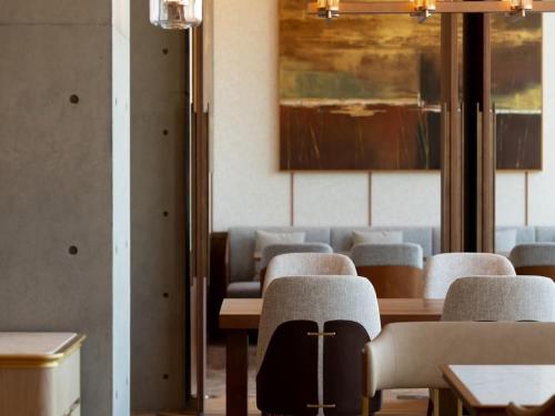 a dining room with chairs and tables and a painting at GREENITY IWATA in Iwata