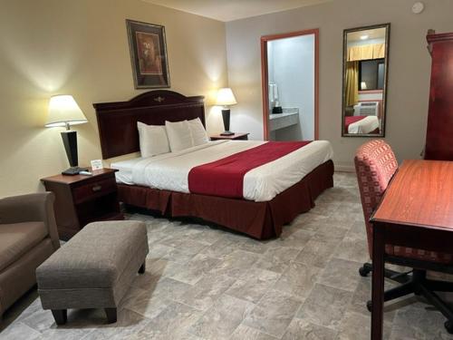 a hotel room with a bed and a desk and chair at Howards Inn Motel in Eunice