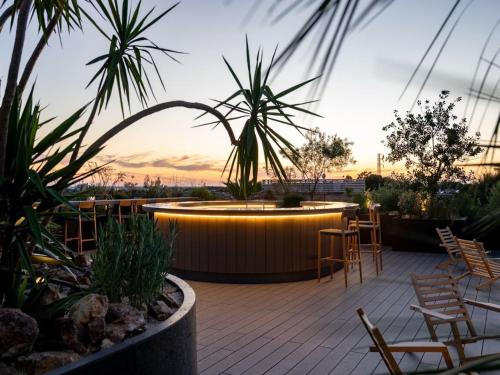 a patio with a bar with chairs and plants at GREENITY IWATA in Iwata