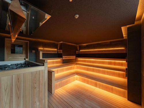 a sauna with wooden flooring and a large tub at GREENITY IWATA in Iwata