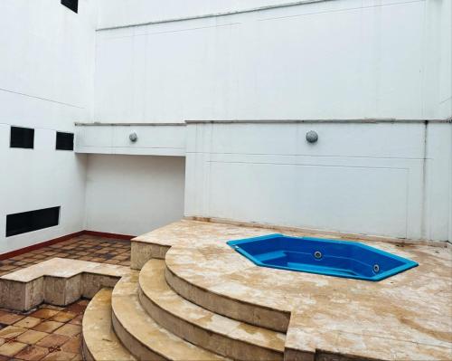 una camera con scale e una ciotola blu sul pavimento di Maljut House & Coffee a Cali