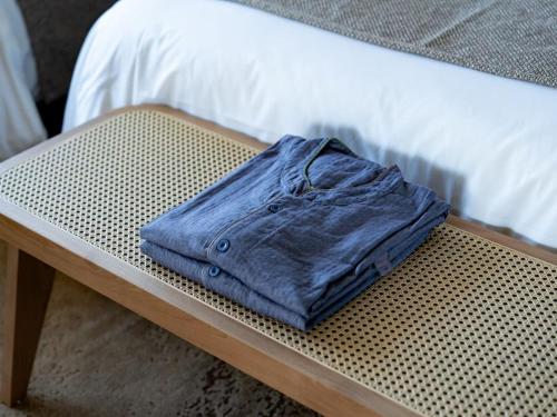 a blue shirt is sitting on a bench next to a bed at GREENITY IWATA in Iwata