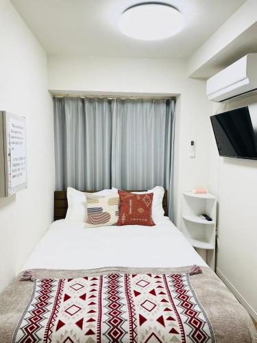 a bedroom with a bed and a window at T-Hotel 浅草 in Tokyo