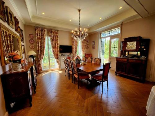 a dining room with a wooden table and chairs at La Campagne Villa Chiangmai in Chiang Mai