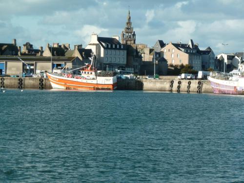 two boats are docked in the water near a city at Ibis Roscoff in Roscoff