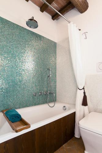 a bathroom with a bath tub and a toilet at B&B Cal Torello in Urbino
