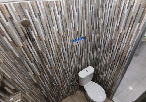 a bathroom with a toilet and a bamboo curtain at Livina's House in Mendut