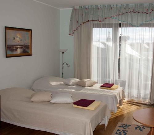 2 Betten in einem Zimmer mit Fenster in der Unterkunft Holiday Apartment Pikk in Pärnu