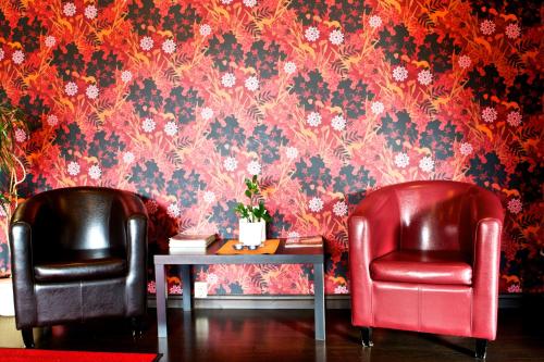 two chairs and a table in a room with wallpaper at Värdshuset Stopet in Grängesberg