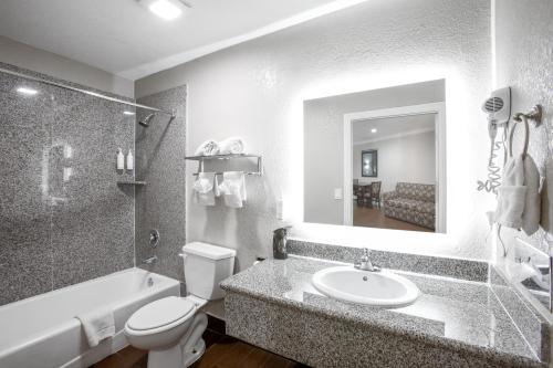 a bathroom with a sink and a toilet and a tub at Elev8 Hotel Los Angeles, LAX in Inglewood