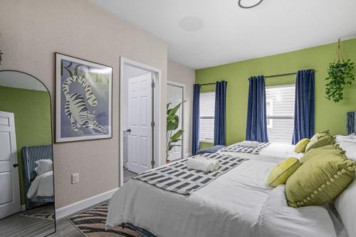 a bedroom with a large bed with green walls at Vibrant Downtown Indy Retreat with Game Room & Patio in Indianapolis