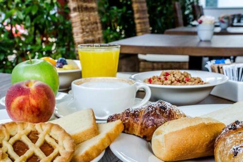 a table with a plate of breakfast foods and fruit at Hotel Silver Milano in Milan