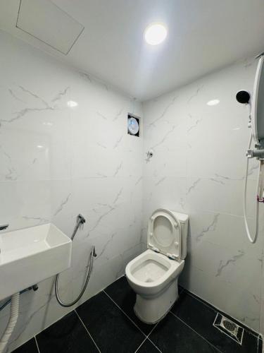 a bathroom with a white toilet and a sink at Ar Rayyan Hotel in Tanah Rata