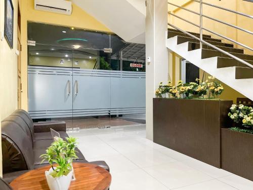 a lobby with a table and a staircase at Kartika Hotel Syariah Pacitan Mitra RedDoorz in Pacitan