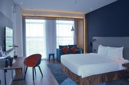 a hotel room with a large bed and a couch at Holiday Inn Express Harbin Qunli by IHG in Harbin