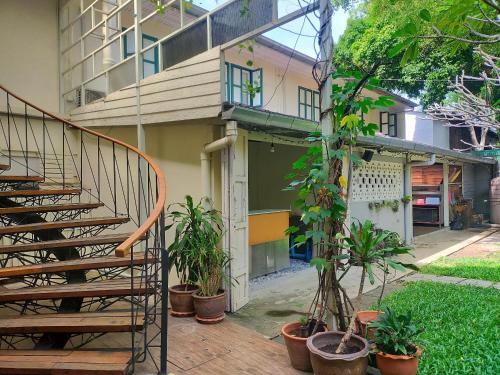 a building with stairs and potted plants in front of it at Baan Wangderm Hotel in Bangkok