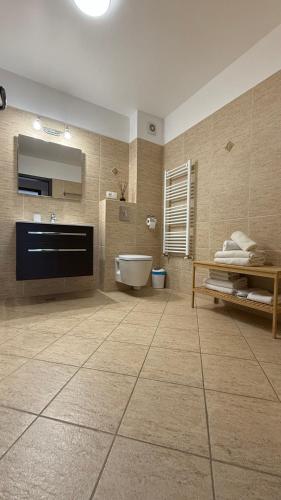 a bathroom with a tub and a toilet and a sink at Coresi Long Stay Apartment in Braşov