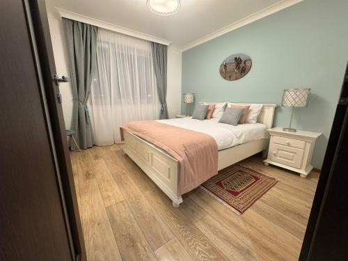 a bedroom with a large bed and a window at Coresi Long Stay Apartment in Braşov