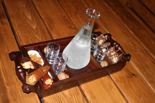 a wooden tray with a bottle of milk and wine glasses at Savaneti Eco Hotel in Tʼelavi