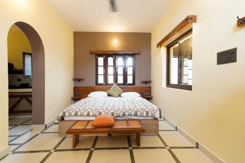 a bedroom with a bed and a table at Aavya Wellness Retreat Center in Rishīkesh
