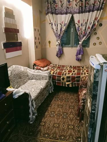 a room with two beds and a window with curtains at الشواربي السياحي كورنيش النيل in Aswan