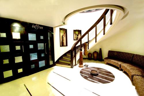 a room with a spiral staircase with a wooden table at Hotel Meera in Raipur