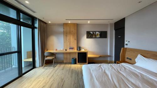 a bedroom with a bed and a desk and a table at La Tree 普椿農場木子莊園 in Donghe