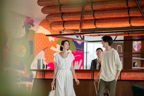a man and a woman standing at a bar at Canopy By Hilton Osaka Umeda in Osaka