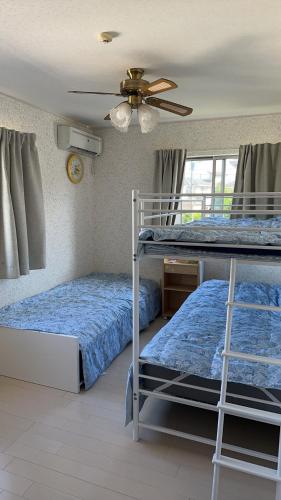 a bedroom with two bunk beds and a ceiling fan at 清水公園四个房间 in Noda
