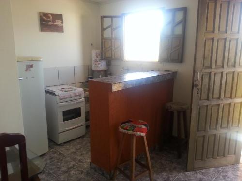 a small kitchen with a counter and a refrigerator at Kitnet Rio Vermelho in Salvador