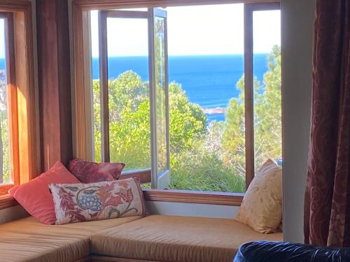 a window seat with a view of the ocean at Above the Bay in Hahei