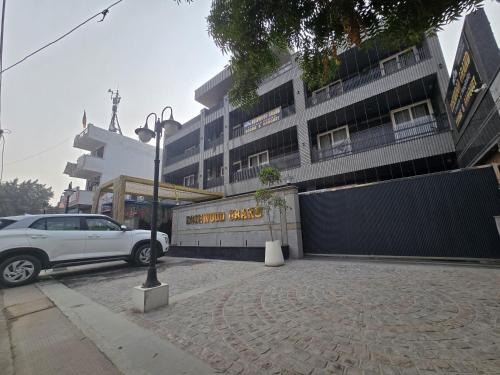 a white car parked in front of a building at Rosewood Grand in Faridabad