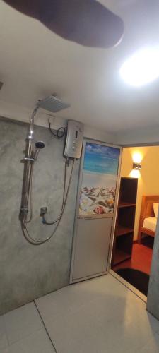 a shower in a bathroom with a painting on the wall at Ayuvilla in Goiyapana
