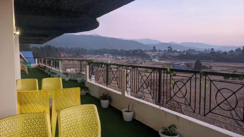 a balcony with chairs and a view of the mountains at Hotel Horizon, Ziro in Ziro