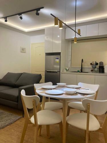 a living room with a table and chairs and a kitchen at Sanremo Oasis Condo in Cebu City