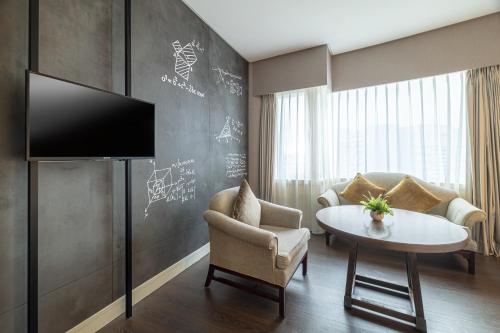 a living room with a tv and a table and a couch at Just Sleep - Taipei NTU in Taipei