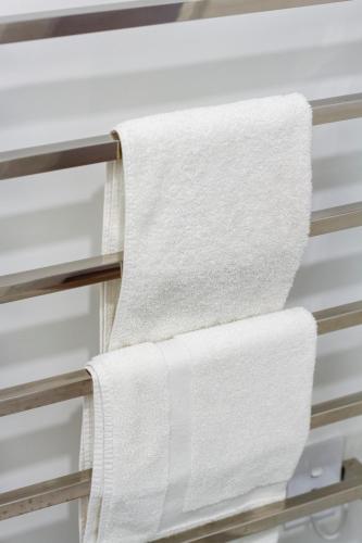 a stack of towels hanging on a shelf at Single-Level Retreat 1 bed 1 bath With Balcony in Christchurch