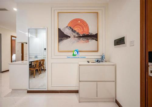 a room with a table and a painting on the wall at the Vinhome Central apartment - The Best Landmark Area in Ho Chi Minh City