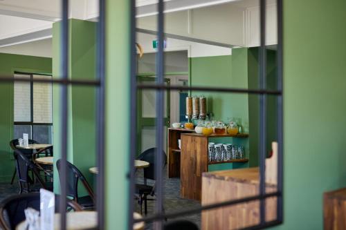 a room with green walls and tables and chairs at Balmoral On York in Launceston
