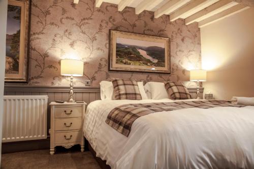 a bedroom with two beds and two lamps at Crofters Lodge in Barrow in Furness